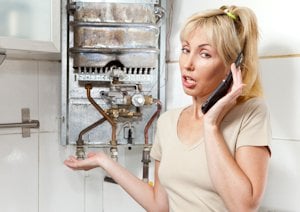 Woman on Phone Pointing to Broken Boiler